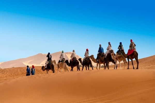 The golden dunes of the Sahara Desert at sunset, a must-see destination included in Morocco travel packages.